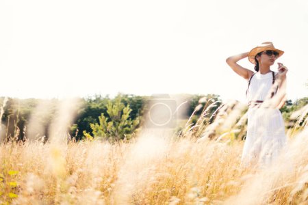 Photo for Beautiful girl in a linen dress in a wheat field. Summer vacation, traveling. Bohemian, modern hippie style. - Royalty Free Image