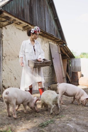 Foto de Elegante joven agricultora que cría cerdos. - Imagen libre de derechos