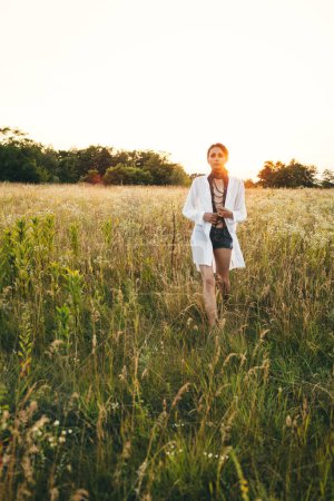 Photo for Portrait of woman in golden sunset light in outdoor meadow. Springtime and summer lifestyle. Wellbeing and zen like meditation activity in outdoor. Loving life. - Royalty Free Image