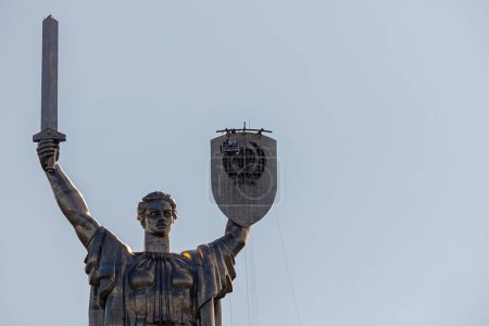 Foto de Kiev, Ucrania - 1 de agosto de 2023: Vista del monumento a la Patria después de retirar el escudo soviético y prepararse para la instalación del escudo de armas de Ucrania. - Imagen libre de derechos