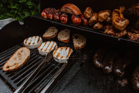 Photo for Beef steaks, camembert and sausages on the grill. Shallow dof - Royalty Free Image