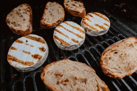 Photo for Grilled camembert, on old dark grille. Shallow dof - Royalty Free Image