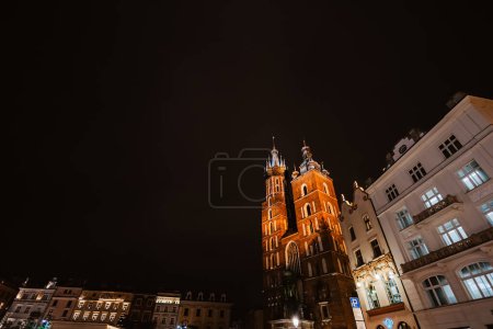 Foto de Basílica de Santa María o Iglesia Mariacki en el casco antiguo de Cracovia o Cracovia, Polonia. La Plaza del Mercado Principal por la noche. - Imagen libre de derechos