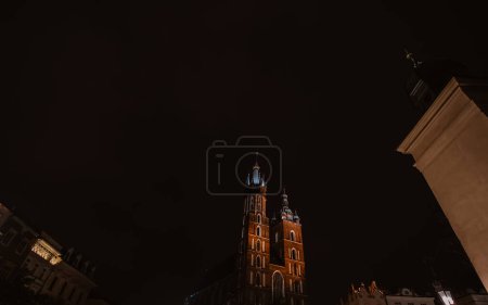 Foto de Basílica de Santa María o Iglesia Mariacki en el casco antiguo de Cracovia o Cracovia, Polonia. La Plaza del Mercado Principal por la noche. - Imagen libre de derechos