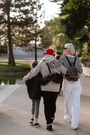 Téléchargez les photos : Photo de famille marchant ensemble dans le parc. - en image libre de droit