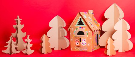 Photo for Christmas Tree and Cardboard playhouse Made Of Cardboard. Unique Trees. New Year or Xmas - Royalty Free Image