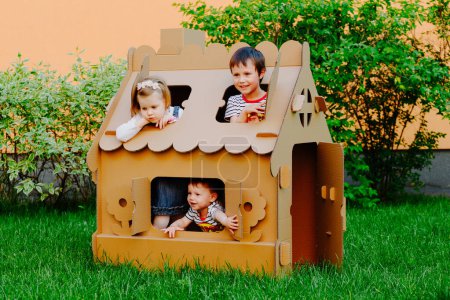 Foto de Los niños juegan en una casa de cartón. Niño divirtiéndose al aire libre - Imagen libre de derechos
