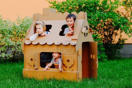Téléchargez les photos : Les enfants jouent dans une maison en carton. Enfant s'amuser à l'extérieur - en image libre de droit