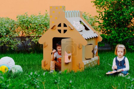Téléchargez les photos : Peinture d'enfants sur la maison de jeux en carton - en image libre de droit