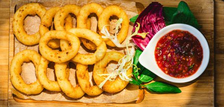Photo for Homemade crunchy fried onion rings with tomato sauce. Shallow dof - Royalty Free Image