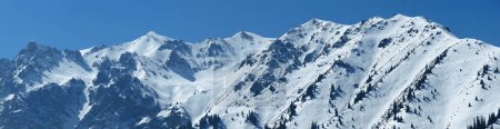 Panoramic view of the mountains near Shymbulak Ski Resort. Snow Mountains. Ile-Alatau National Park. Almaty, Kazakhstan.