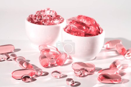 Photo for Pink transparent capsules, Food supplement oil filled fish oil, omega 3, omega 6, omega 9, vitamin A, vitamin D, vitamin E, flaxseed oil. - Royalty Free Image