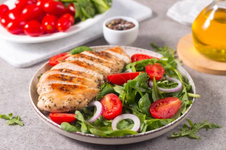 Foto de Salad with grilled chicken fillet meat, fresh vegetables, spinach, ruccola, red onion and tomato. Healthy menu. Diet food. Top view. Banner - Imagen libre de derechos