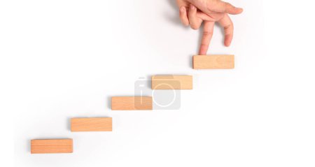 Photo for Hand liken person stepping up a toy staircase wood - Royalty Free Image