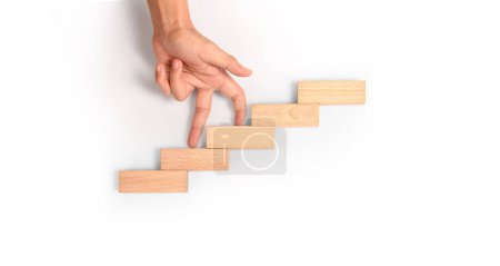 Comparación de mano persona escalando una escalera de juguete madera