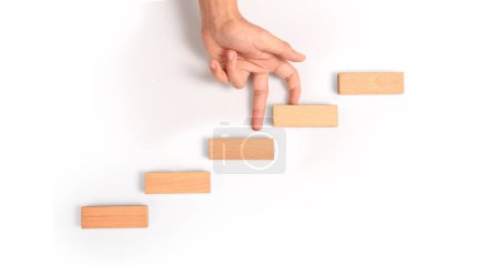 Foto de Comparación de mano persona escalando una escalera de juguete madera - Imagen libre de derechos