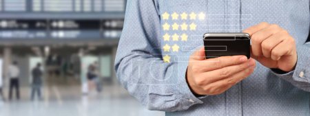 Man holding smartphone device and touching screen with five star rating feedback icon