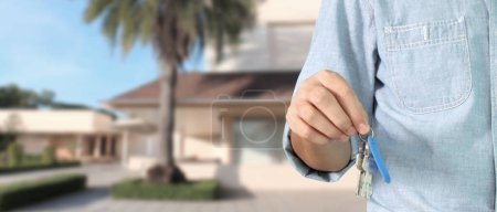 Photo for Real estate agent handing over  house keys in hand - Royalty Free Image