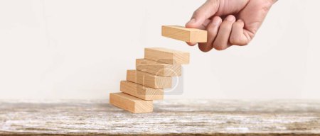 Photo for Hand liken business person stepping up a toy staircase - Royalty Free Image