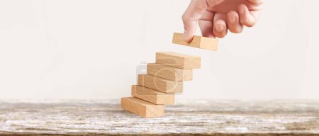 Foto de Comparación de manos persona de negocios escalando una escalera de juguete - Imagen libre de derechos