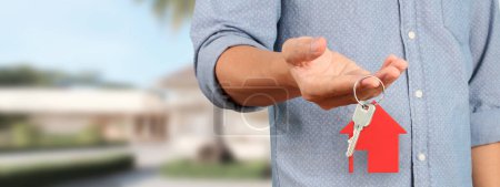Photo for Real estate agent handing over a house keys in hand - Royalty Free Image