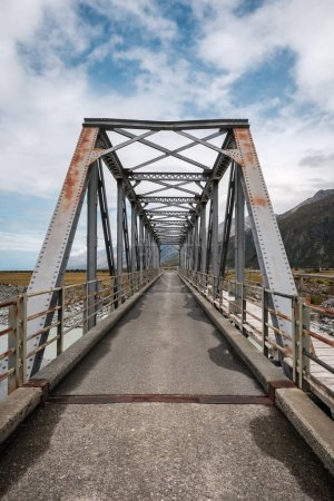 Téléchargez les photos : Iron bridge over the Hooker River near Mount Cook in the South Island of New Zealand with mountains in the distance - en image libre de droit