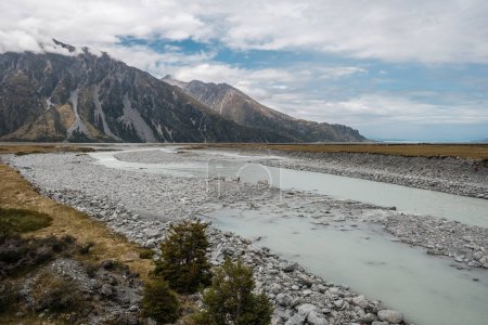 Téléchargez les photos : Hooker River flowing towards the Tasman River near Mount Cook in the South Island of New Zealand with mountains in the background - en image libre de droit