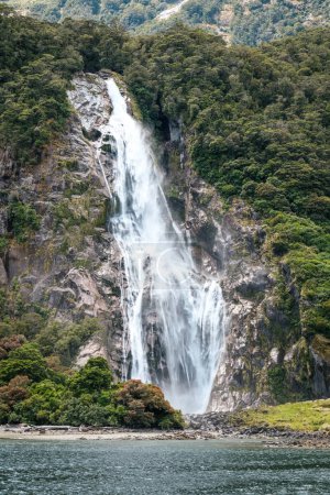 Bowen Falls cascading over rocks into Milford Sound in Fiordland on the South Island of New Zealand