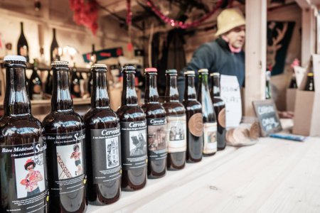 Foto de Sarlat-la-Caneda, Nouvelle-Aquitaine, Francia - 16 de diciembre de 2023: Un puesto de venta de cerveza artesanal en el mercado navideño de Sarlat-la-Caneda, en la región francesa de Dordoña - Imagen libre de derechos