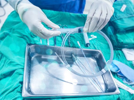 Téléchargez les photos : L'infirmière prépare un fil de guidage pour le matériel médical pour l'emballage d'intervention chirurgicale et stérile - en image libre de droit