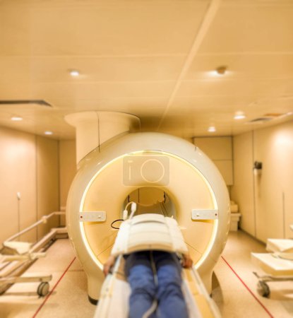 Photo for A patient lies down comfortably on the MRI scanner, undergoing a relaxing MRI scan to assess the upper abdomen, providing crucial medical insights. - Royalty Free Image