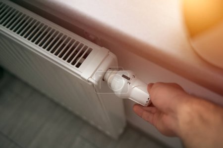 Téléchargez les photos : Baisse de la chaleur du radiateur. Économiser de l'énergie en hiver. Concept d'une liste de conseils pour réduire les factures de services publics. - en image libre de droit