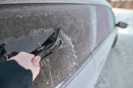 Photo for Scraping ice. Winter season vehicle glass cleaning. Clearing and removing snow and ice from car windows - Royalty Free Image