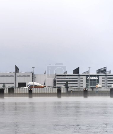 Foto de 24.12.2022 Europe, Geman, Hamburg. Airbus plant and repair hangar on the Elbe river. International airlines planes are being fixed and fitted in front of the Airbus plant in Hamburg - Imagen libre de derechos