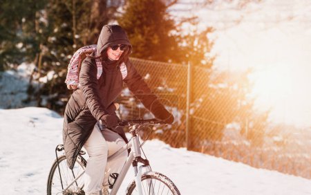 Foto de Mujer paseos en bicicleta en invierno nieve - Imagen libre de derechos