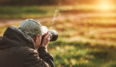 Téléchargez les photos : Homme prenant paysage photo avec un grand appareil photo professionnel - en image libre de droit