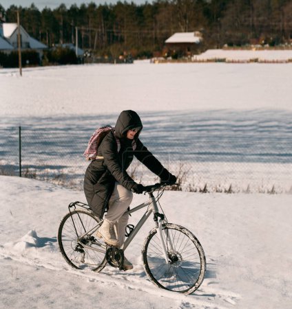 Foto de Mujer paseos en bicicleta en invierno nieve - Imagen libre de derechos