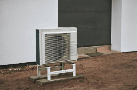 Modernes Haus mit effizienter Wärmepumpe reduziert Wohnkostenkonzept. Wärmepumpe - effiziente Wärmequelle. Nachhaltige Heizung für die Zukunft.