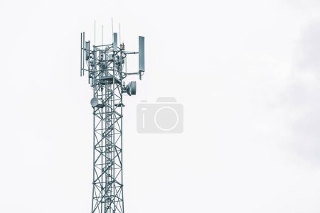 Foto de Una torre de telefonía celular en un campo con árboles en el fondo. - Imagen libre de derechos