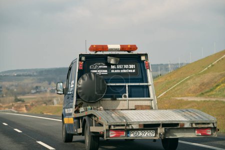 Foto de 16.04.2023 Polonia, Europa. Una grúa plana vacía conduce por una carretera. - Imagen libre de derechos