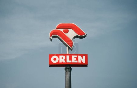 Foto de 08.04.2023 Polonia, Europa. Logotipo de la petrolera polaca "Orlen" en el fondo del cielo azul. Logotipo de PKN Orlen con fondo azul: Orlen es el mayor minorista de gasolina de Polonia. - Imagen libre de derechos