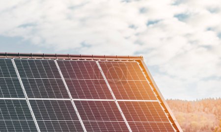 Téléchargez les photos : Panneaux solaires sur le toit. Concept d'utilisation du photovoltaïque dans les zones rurales et rurales pour un avenir durable. Maison moderne avec une source alternative d'énergie électrique. - en image libre de droit