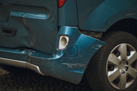 Closeup of a damaged car. Rear bumper dent. Concept of road traffic accident reduction campaign