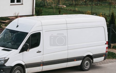 Biały van dostawczy stoi na poboczu drogi. Makieta dostawy od drzwi do drzwi. Pojęcie logistyki.