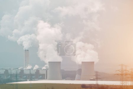 Photo for Two large concrete cooling towers with smoke coming out of them. Coal power plant. - Royalty Free Image