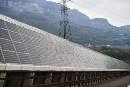 Photo for Solar modules at Italian highway. Solar Highways is a noise barrier along the motorway - Royalty Free Image