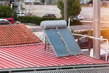 Effiziente solare Warmwasserbereitung. Zeitgenössischer Drucksammler auf dem Dach. Solare Warmwasserbereitung. Warmes Wasser aus der Sonne.