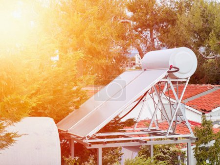 Téléchargez les photos : Chauffage solaire efficace de l'eau. Collecteur de pression contemporain sur le toit. Chauffe-eau solaire. Eau chaude du soleil. - en image libre de droit