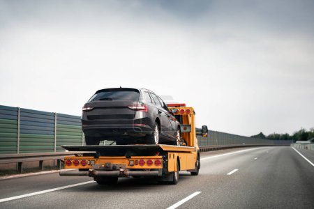 Photo for Tow truck with broken car on country road. Tow truck transporting car on the highway. Car service transportation concept. - Royalty Free Image