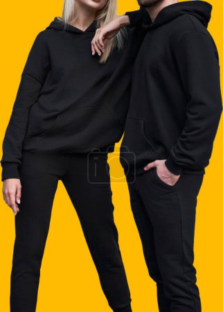 Stilvolles Hoodie-Mockup. Modische Herbst-Streetwear für junge Paare. Frau und Mann tragen schwarze Kapuzenpullis ohne Logo. Kein Logo, keine Sportbekleidung. Langarm-Sweatshirt-Attrappe